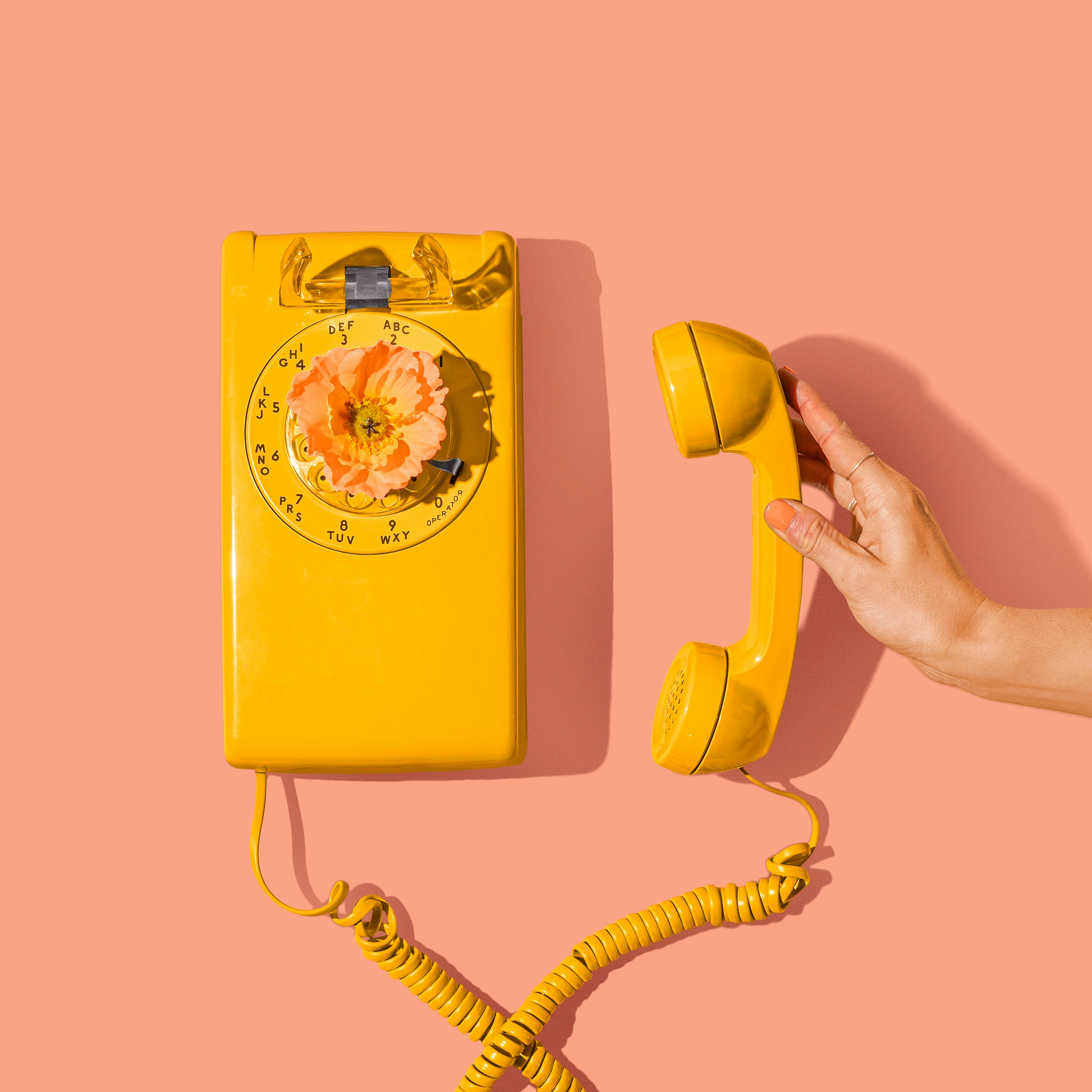 Yellow phone on a peach background